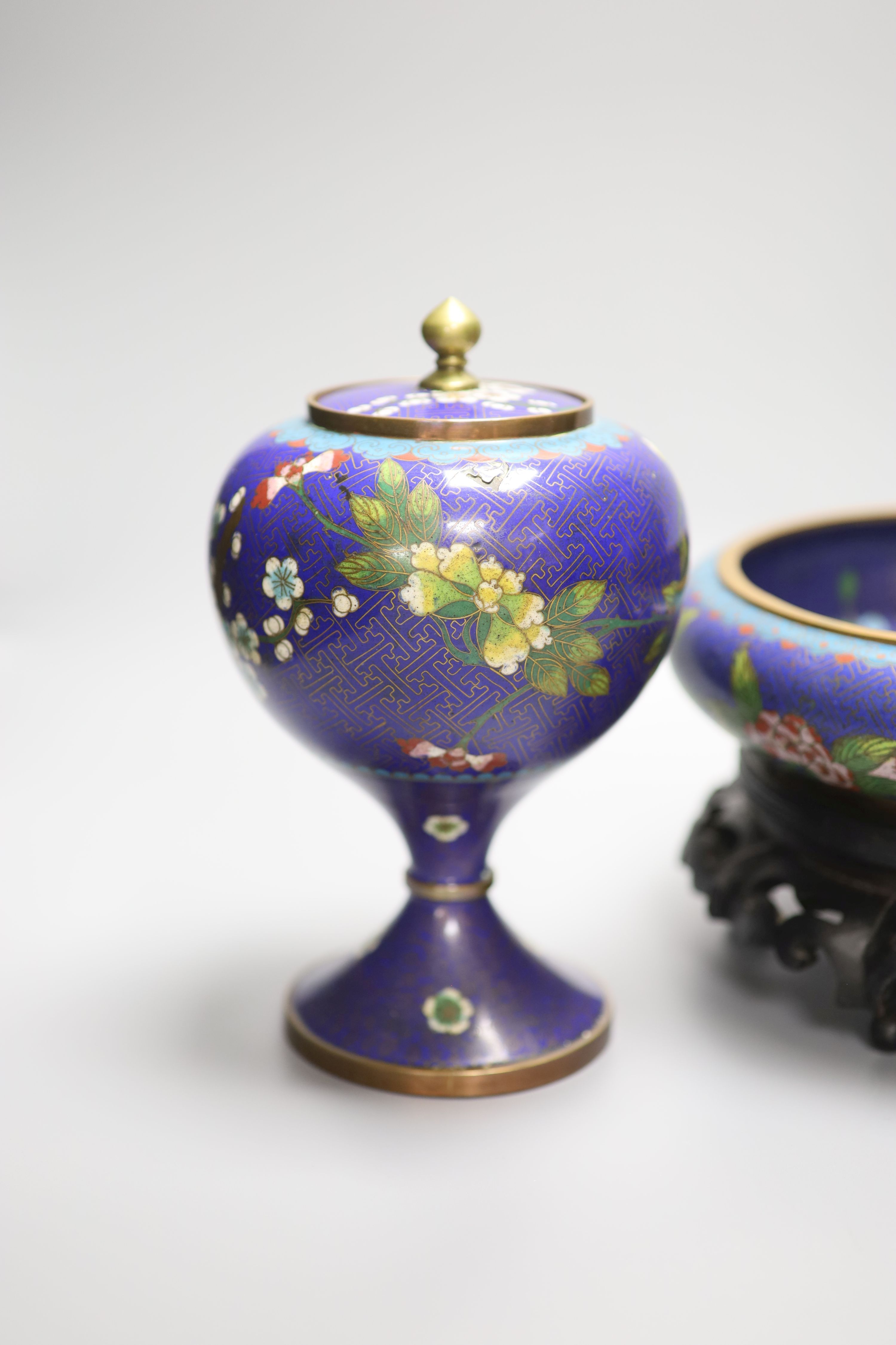 A pair of early 20th century Chinese cloisonne enamel jars and covers and a similar bowl and wood stand, tallest 20cm